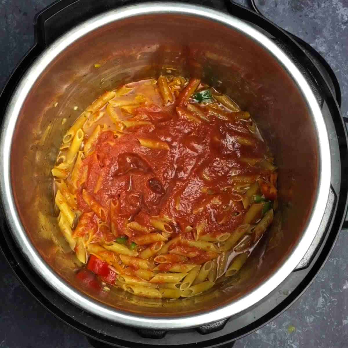 Spread the tomato puree all over the pasta. Do not stir after adding the pasta. Push the dry pasta slightly so that it is covered in liquid
