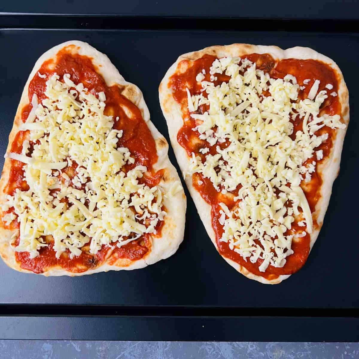 Top naan with pizza sauce and cheese.