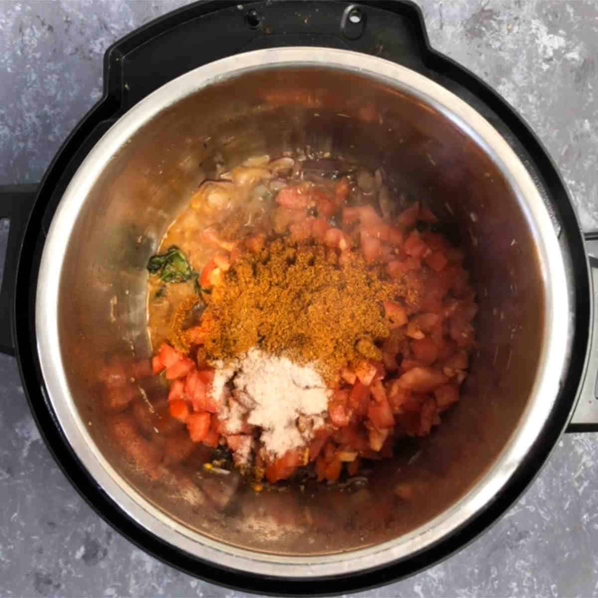 Add the tomatoes, masala powder, and salt.