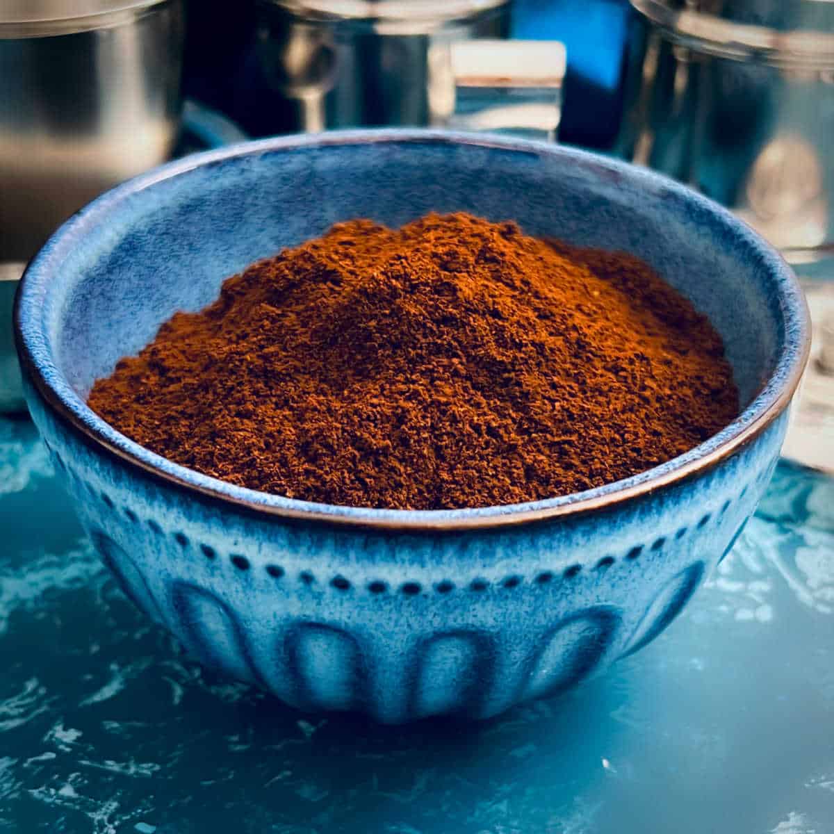 Ground coffee placed in a blue bowl.