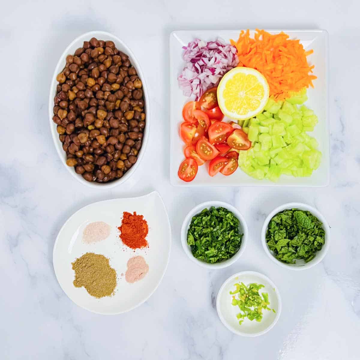 Kala chana chaat ingredients placed on a marble surface.
