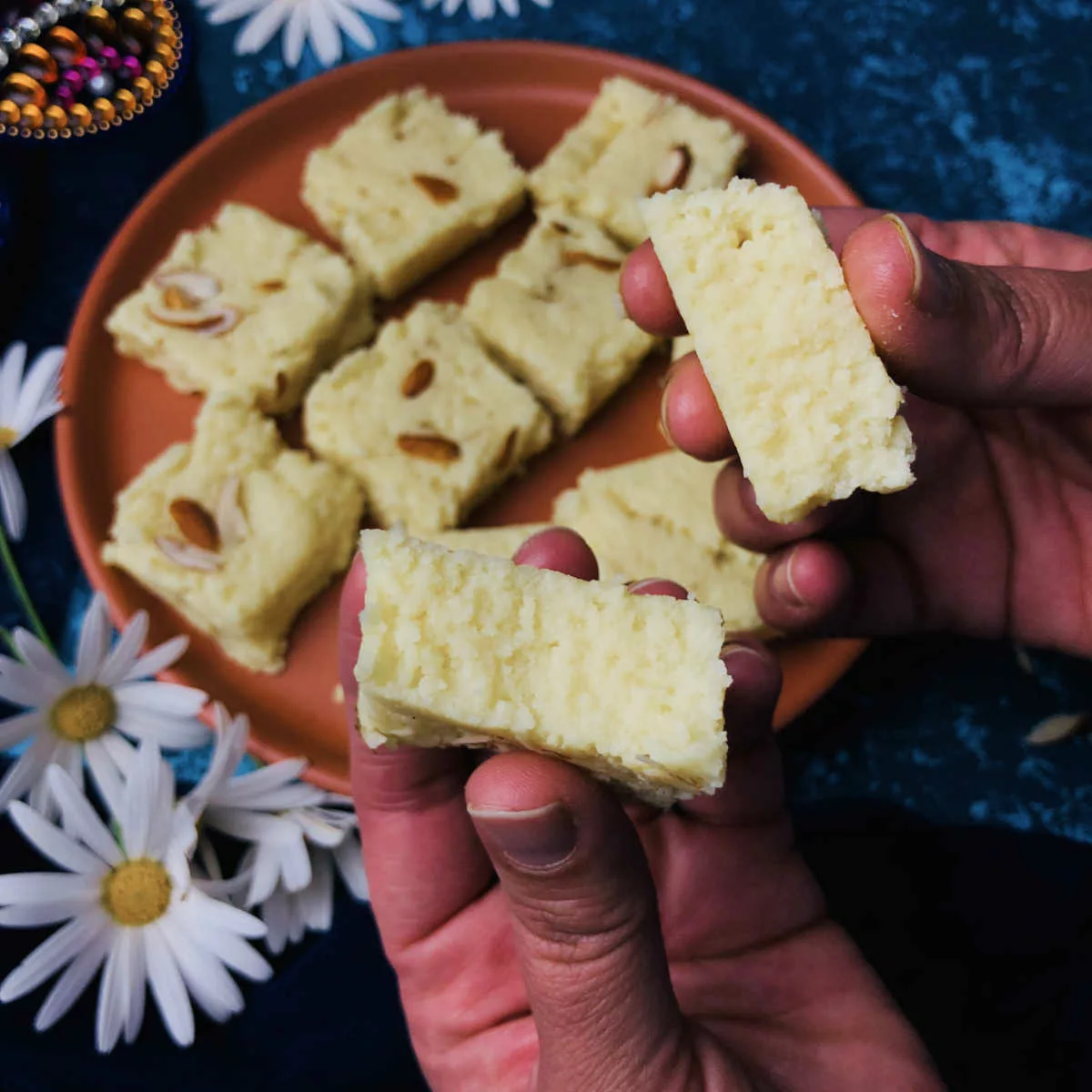 Milk powder barfi cut into two pieces to show the interior texture.