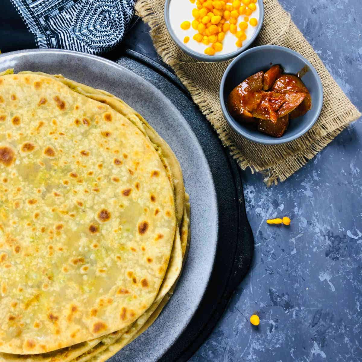 Peas paratha served with pickle and yogurt.