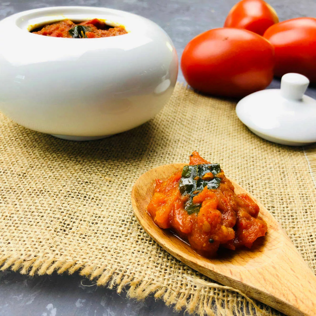 Tomato pickle placed on wooden serving spoon.