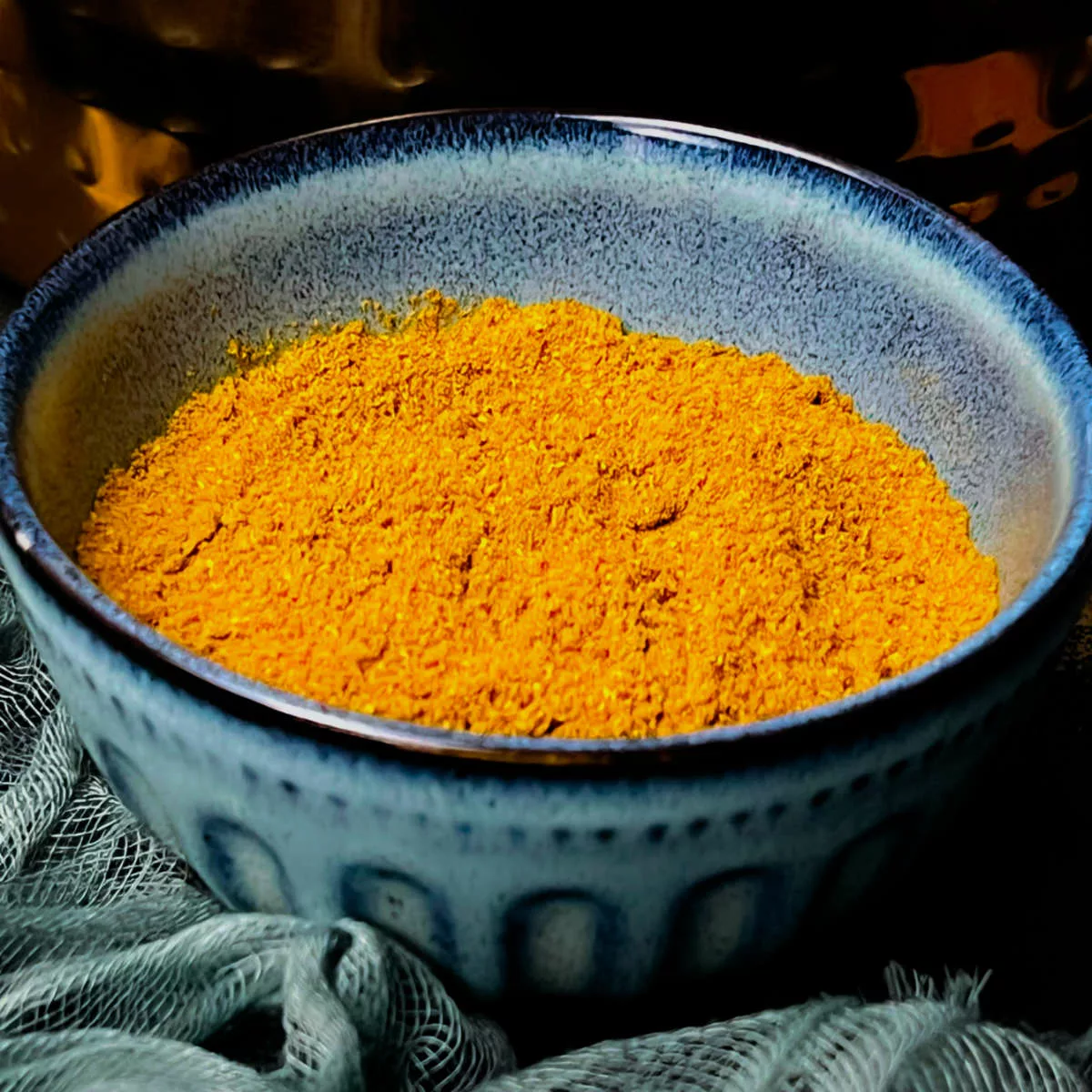 Homemade curry powder in a blue bowl.