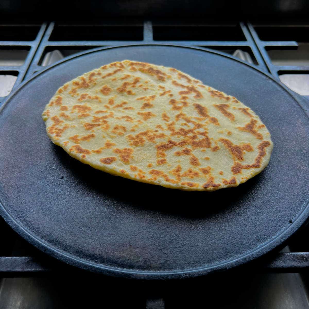Reheating naan on a skillet.