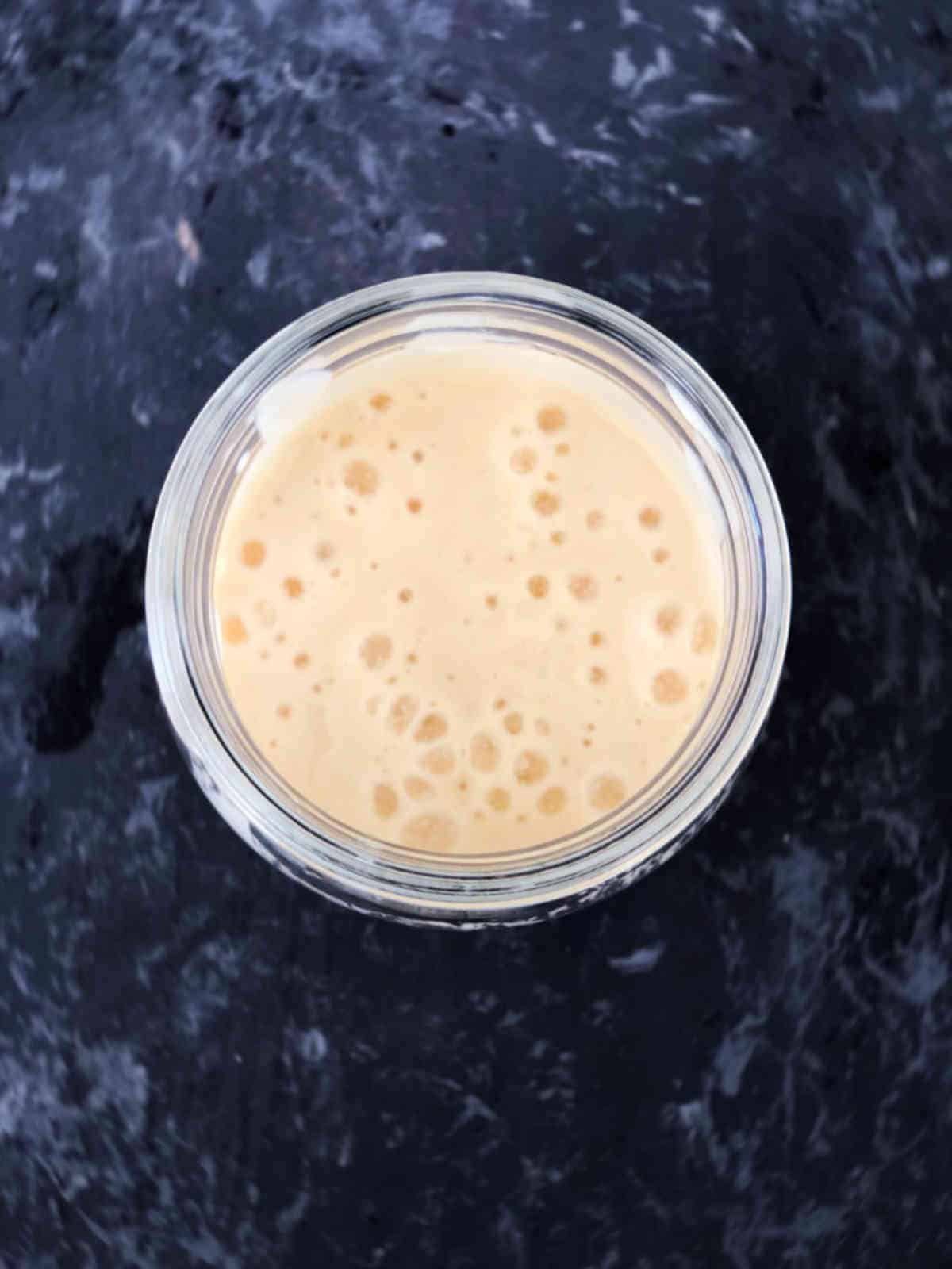 Bubbly sourdough starter in a glass jar.