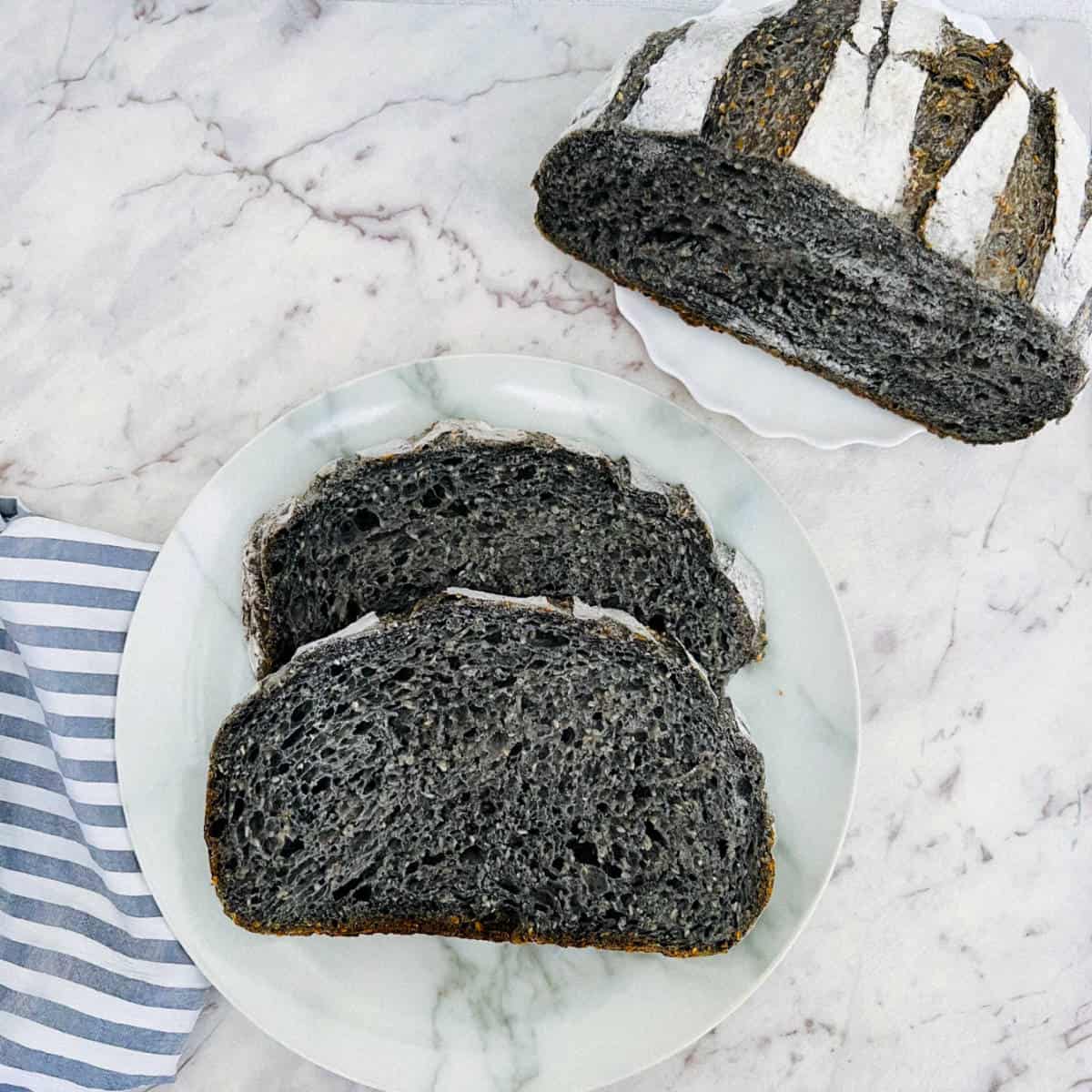 Sliced sourdough charcoal bread placed on a plate.