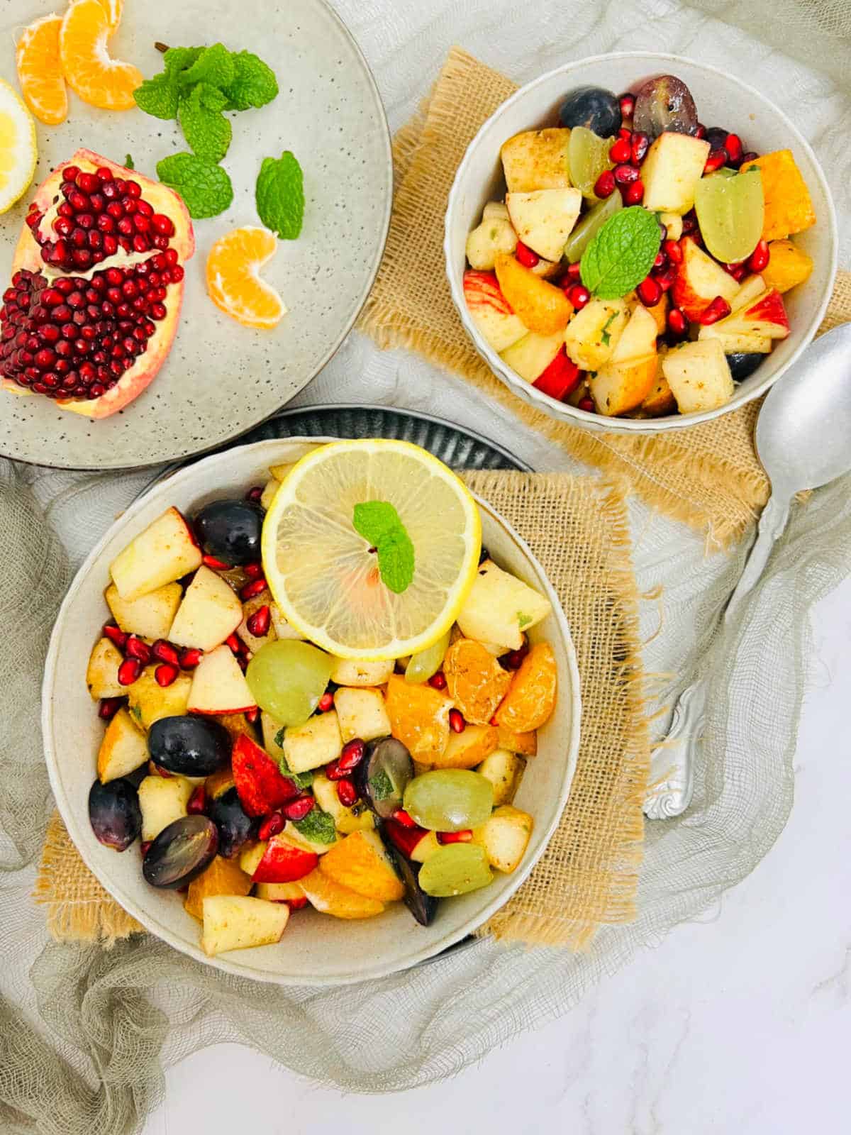 Fruit chaat served on a plate with fruits in the background.