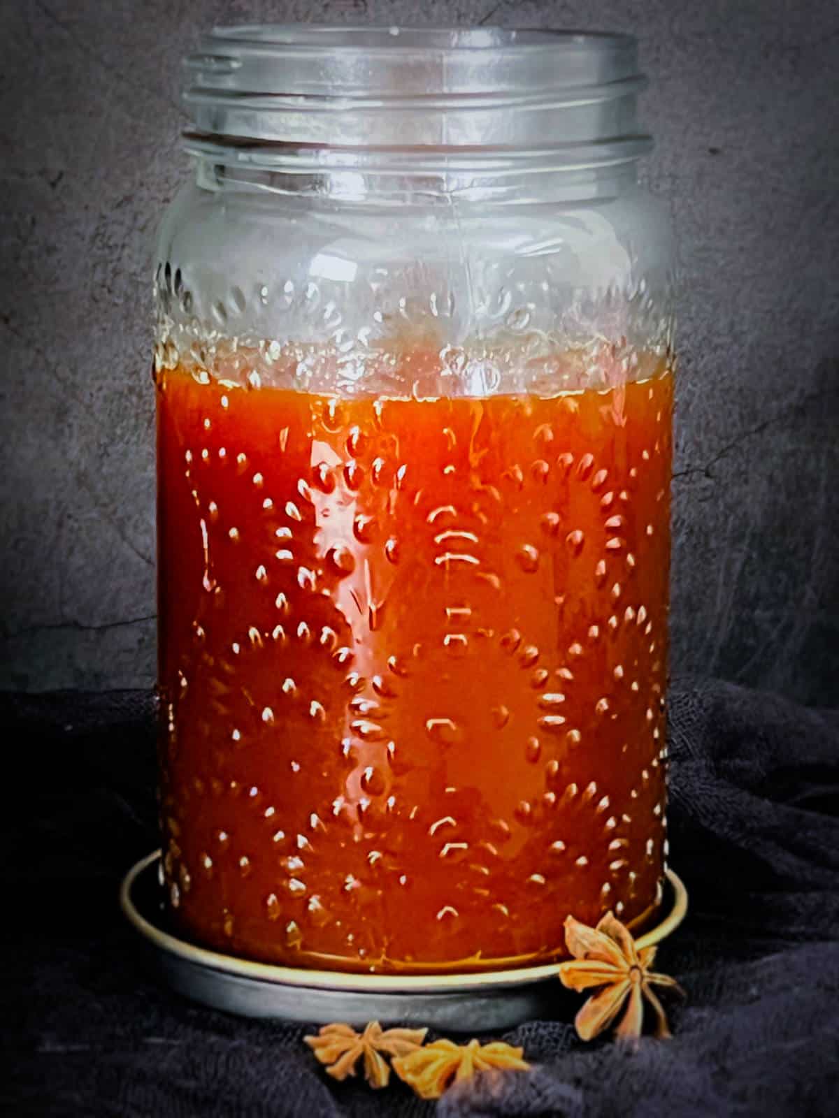 Spiced ginger syrup in a glass jar.