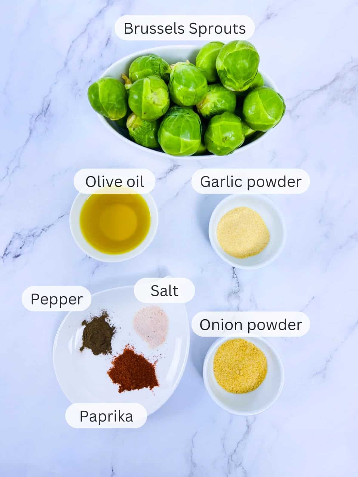 Ingredients to make Brussels sprouts placed on a marbel background.