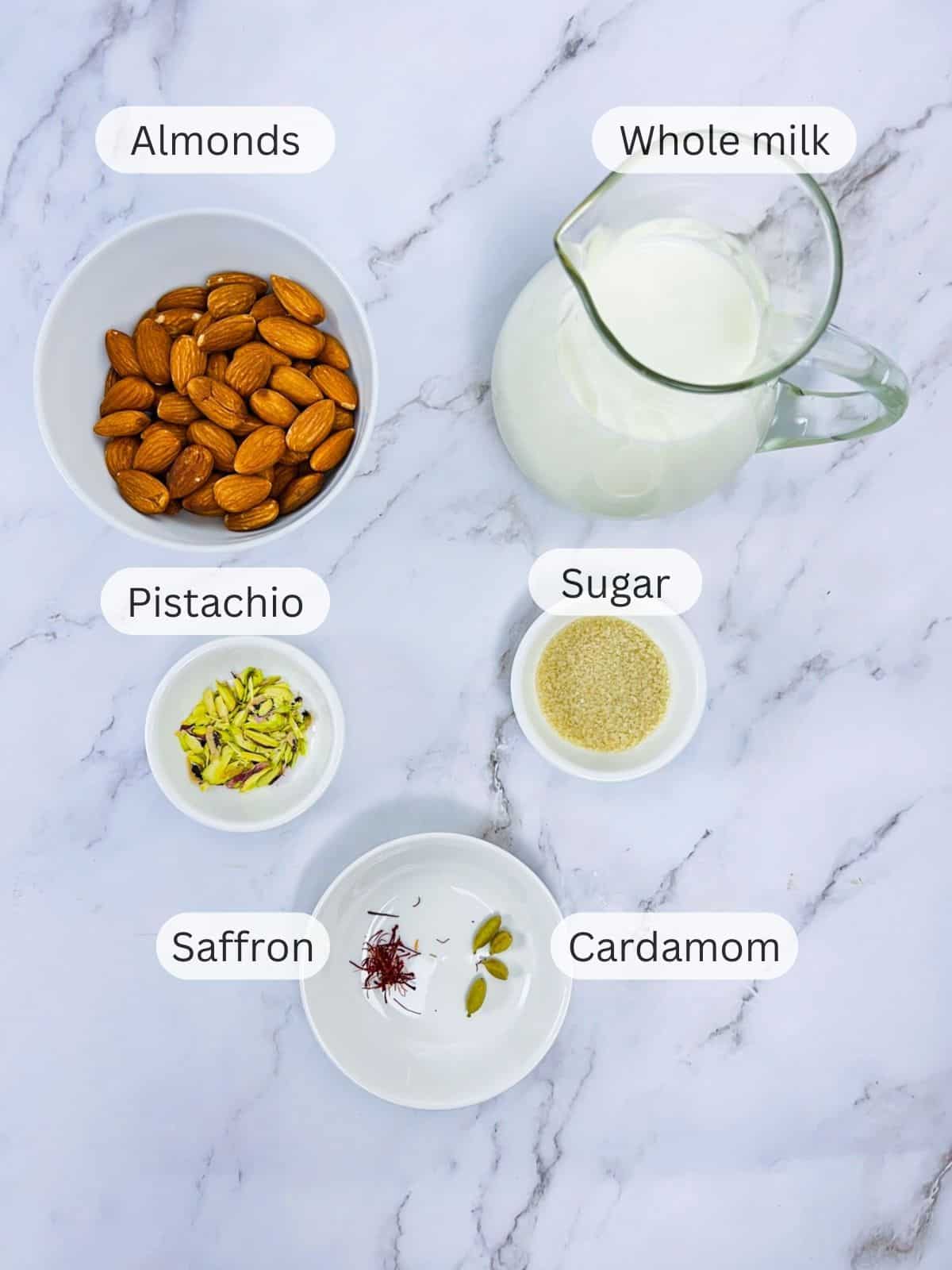 Badam milk ingredients placed on a white marble board.