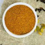 Chana masala powder placed in a white bowl.