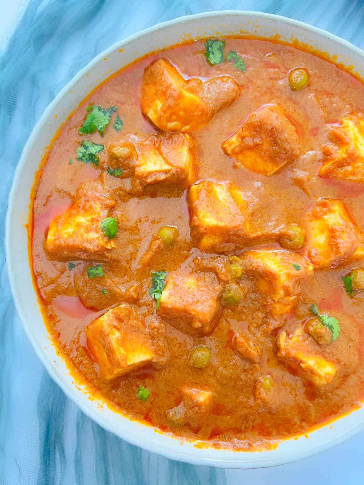 Matar paneer placed in a white bowl.