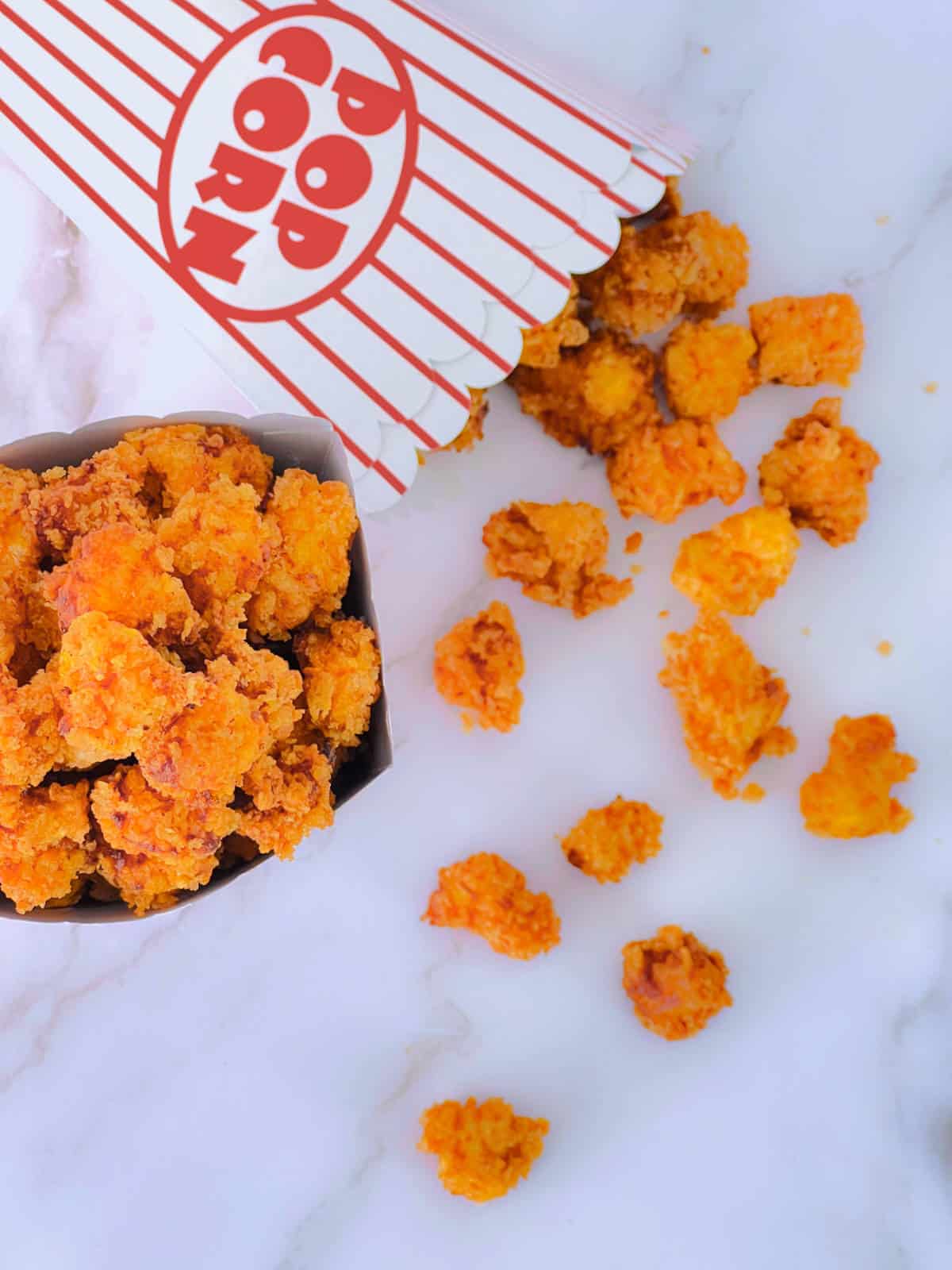 Popcorn chicken placed in a paper box on a marble background.