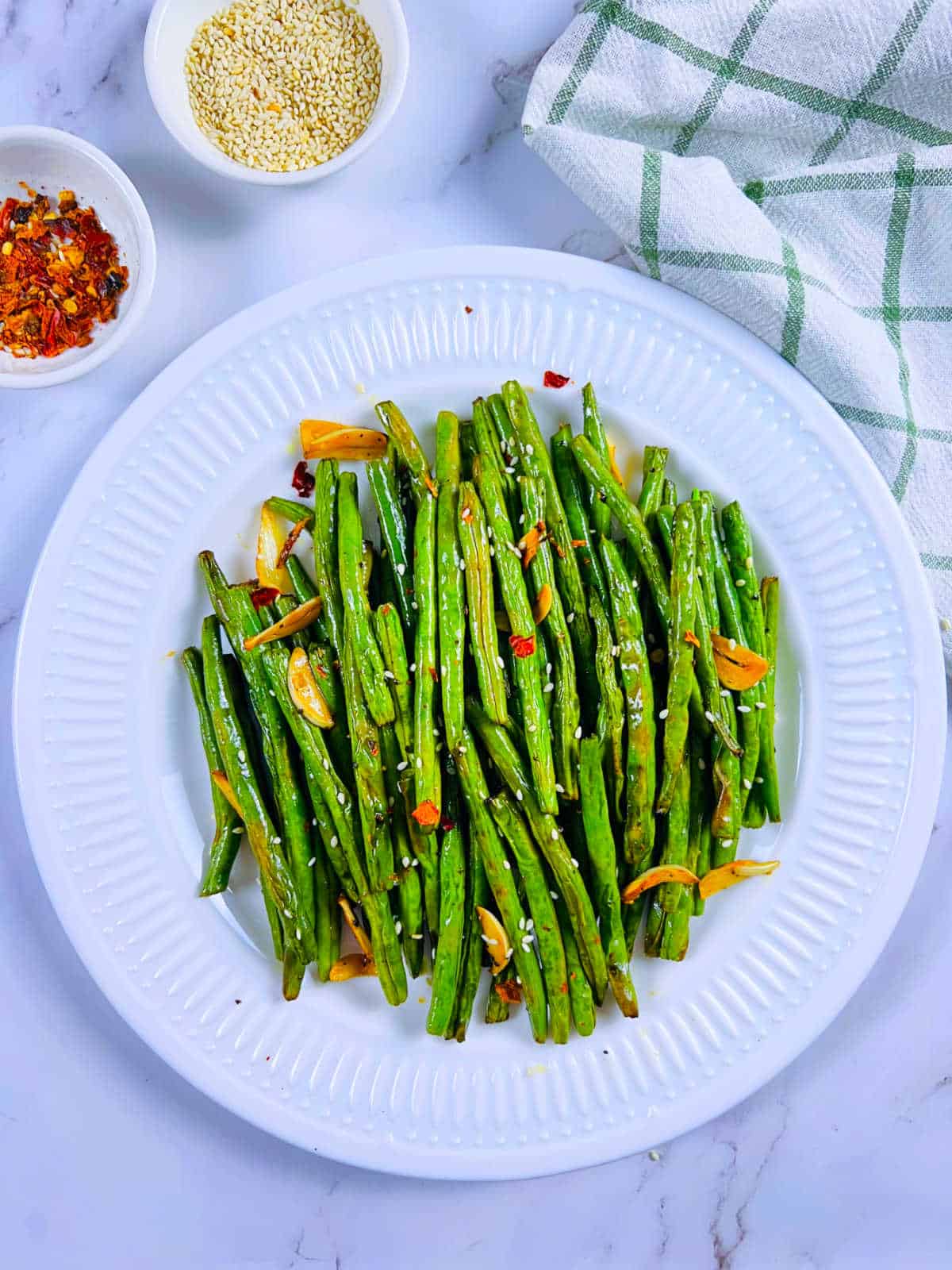 Air fryer green beans placed on a white plate.