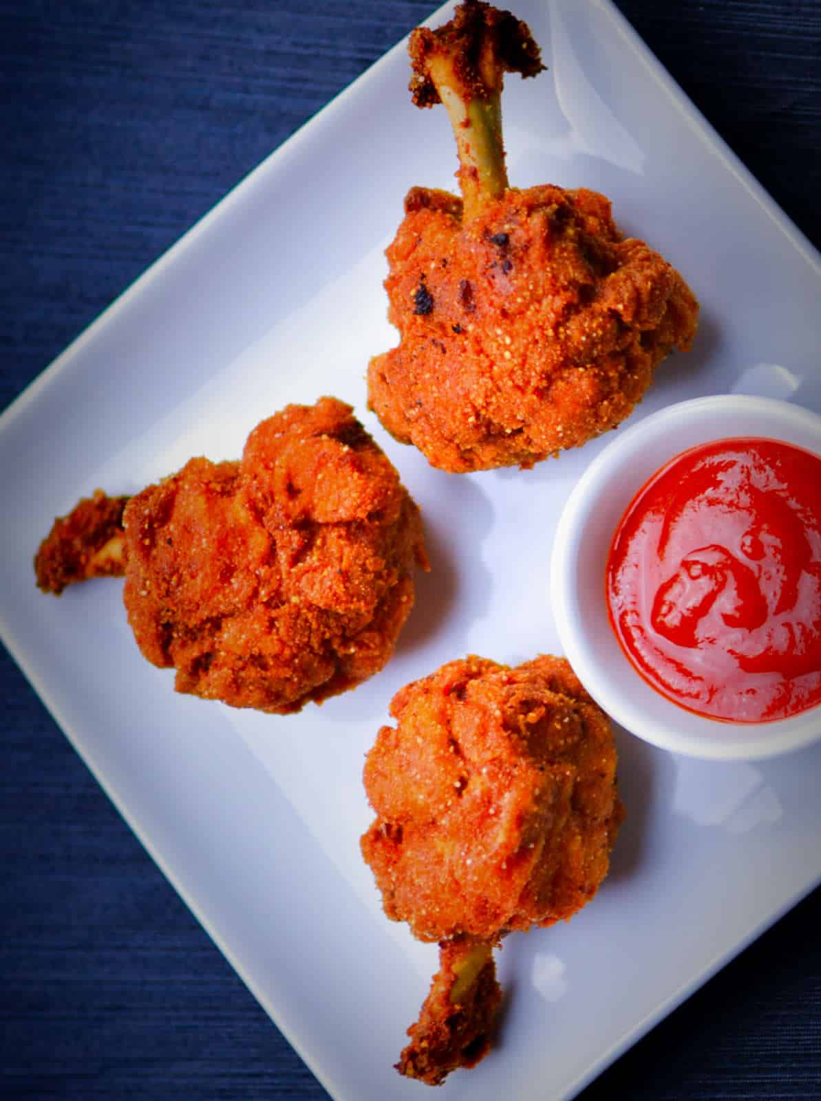 Chicken lollipops placed on a white plate.