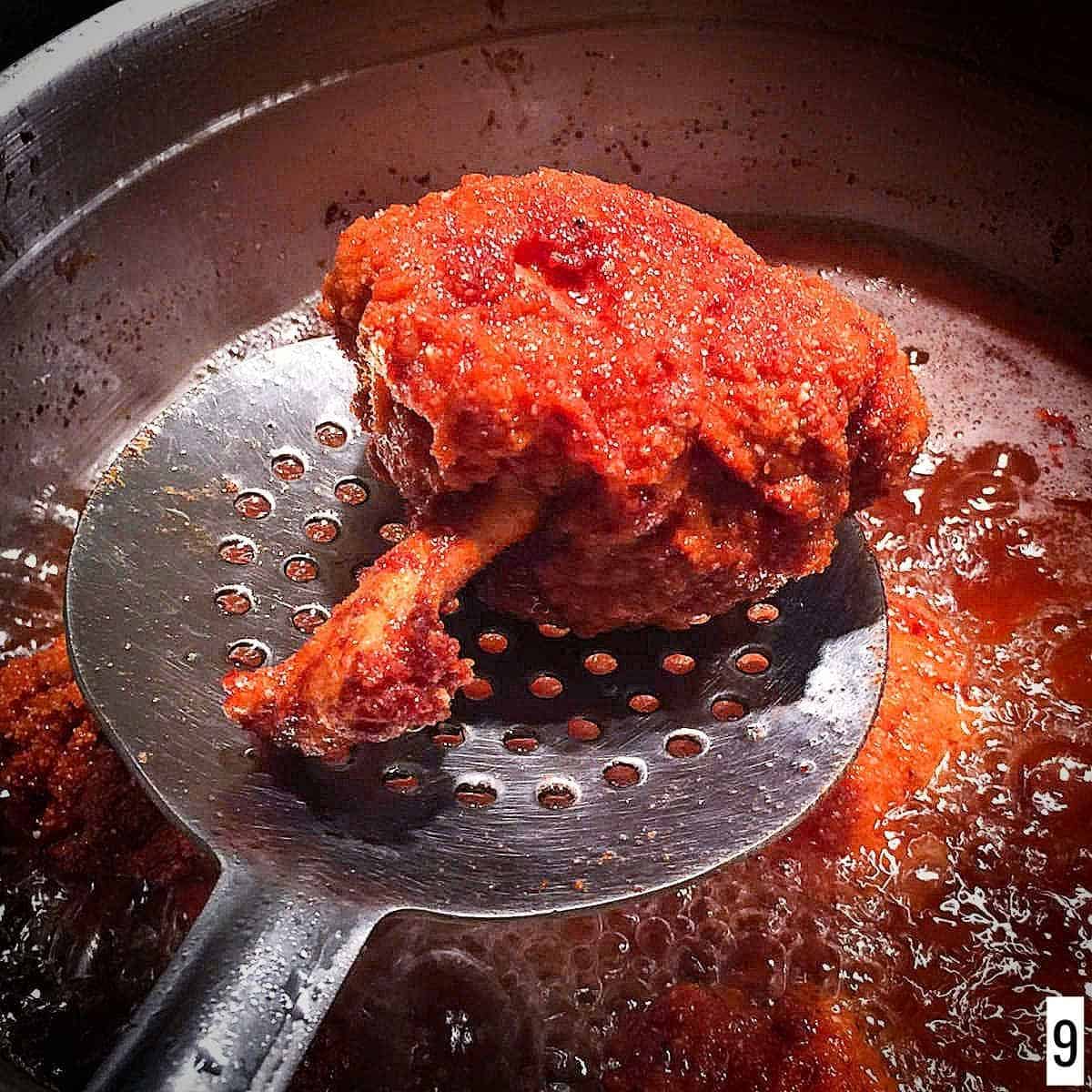 Deep fried chicken lollipop placed on the strainer.