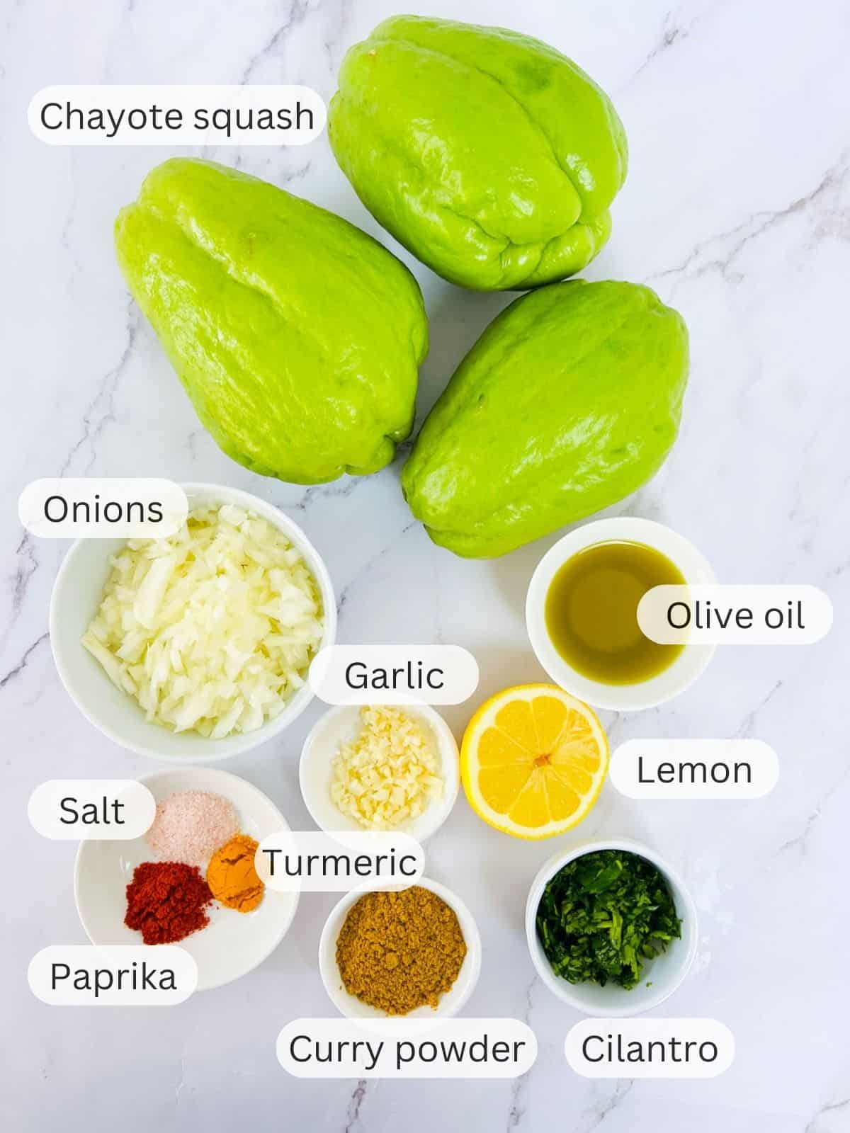 Ingredients to make pan-fried chayote squash placed on a marble surface.
