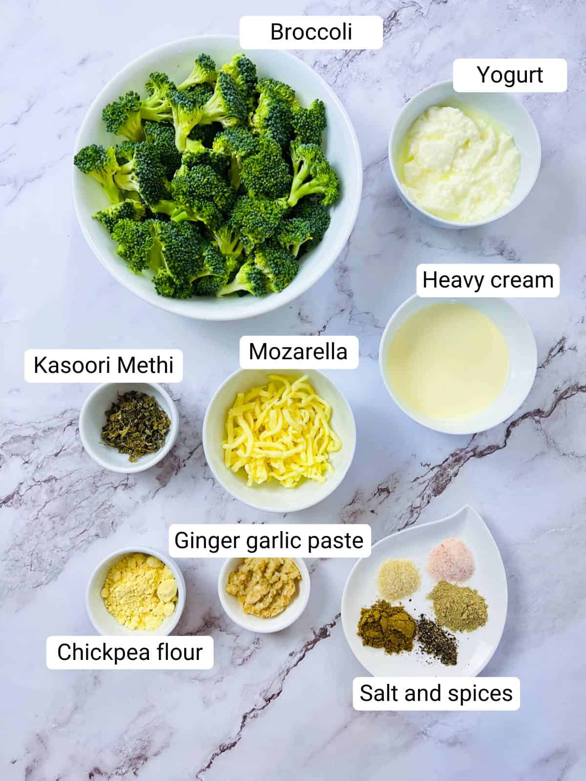 Air fryer malai broccoli ingredients placed on a marble surface.
