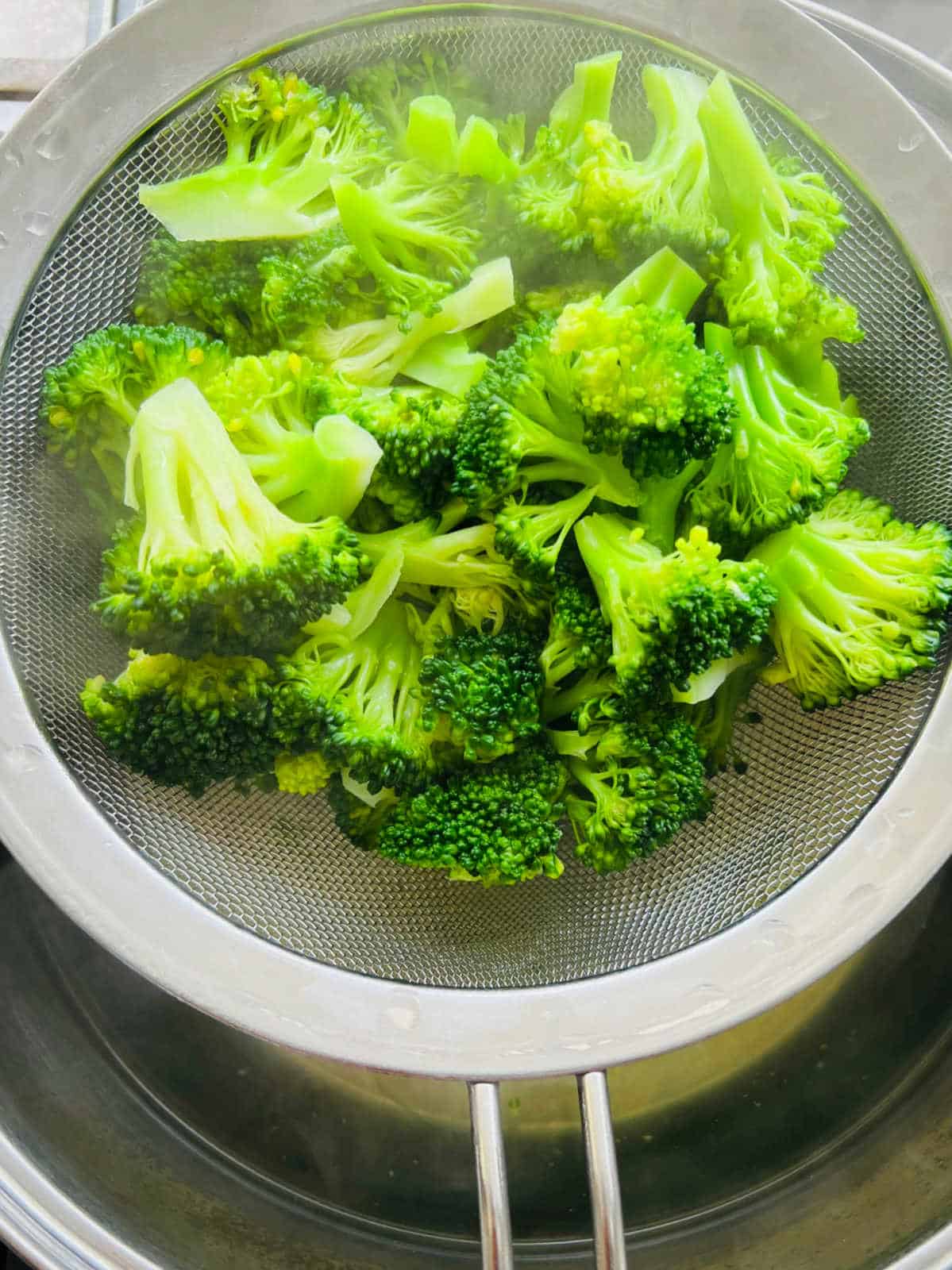Step showing blanching broccoli in hot water.