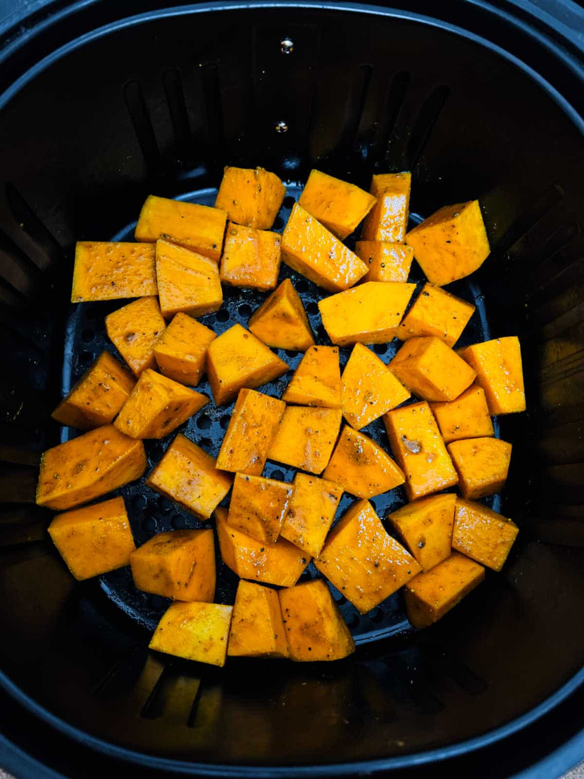 Pumpkin cubes in the air fryer basket.