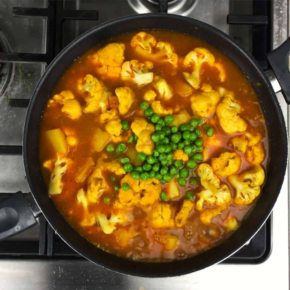 Add cauliflower and peas, and simmer until done.
