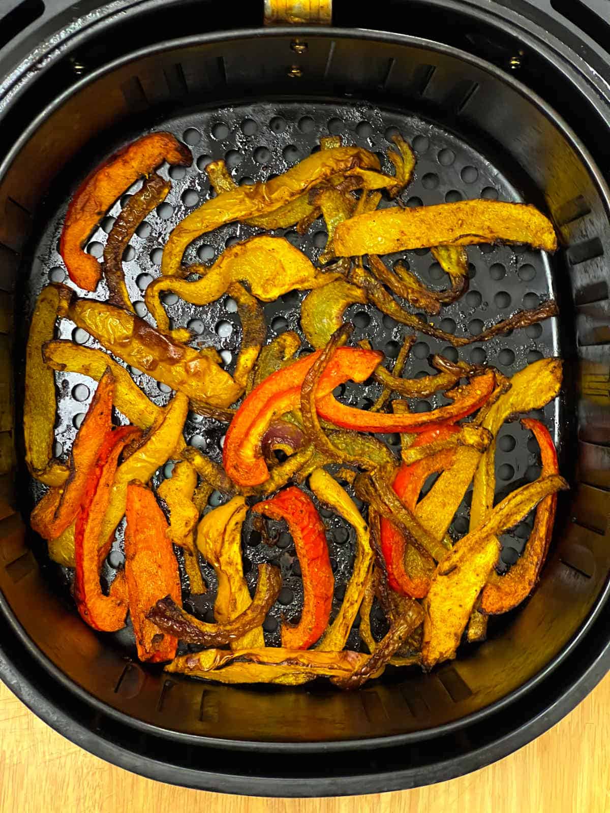 Roasted bell peppers in air fryer basket.