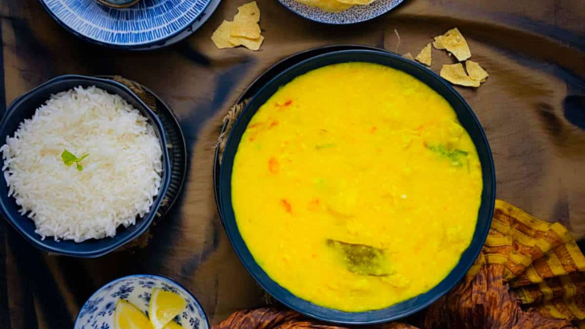 Lauki moong dal served with rice and lemon pieces.
