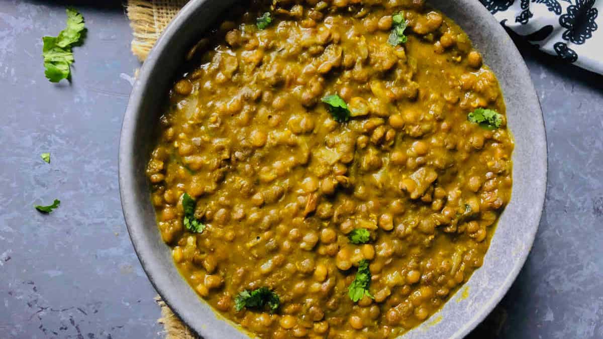 Brown lentil curry in a grey bowl.