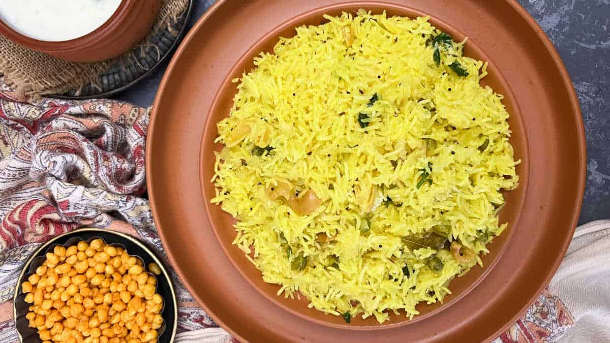 Cabbage rice served in a brown plate with boondi and yogurt.