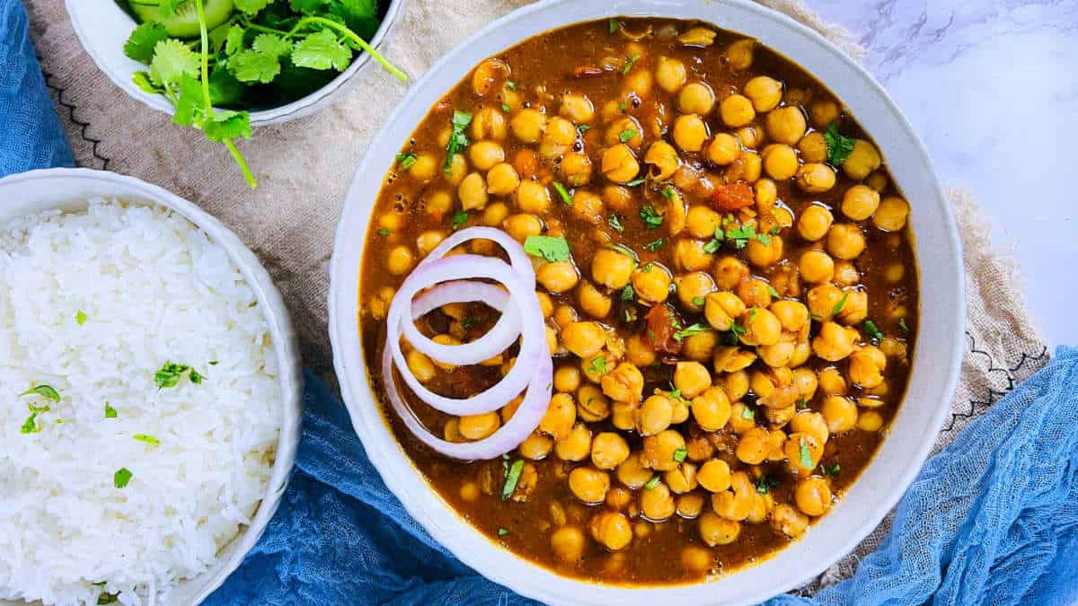 Chana masala served with rice in a white bowl.