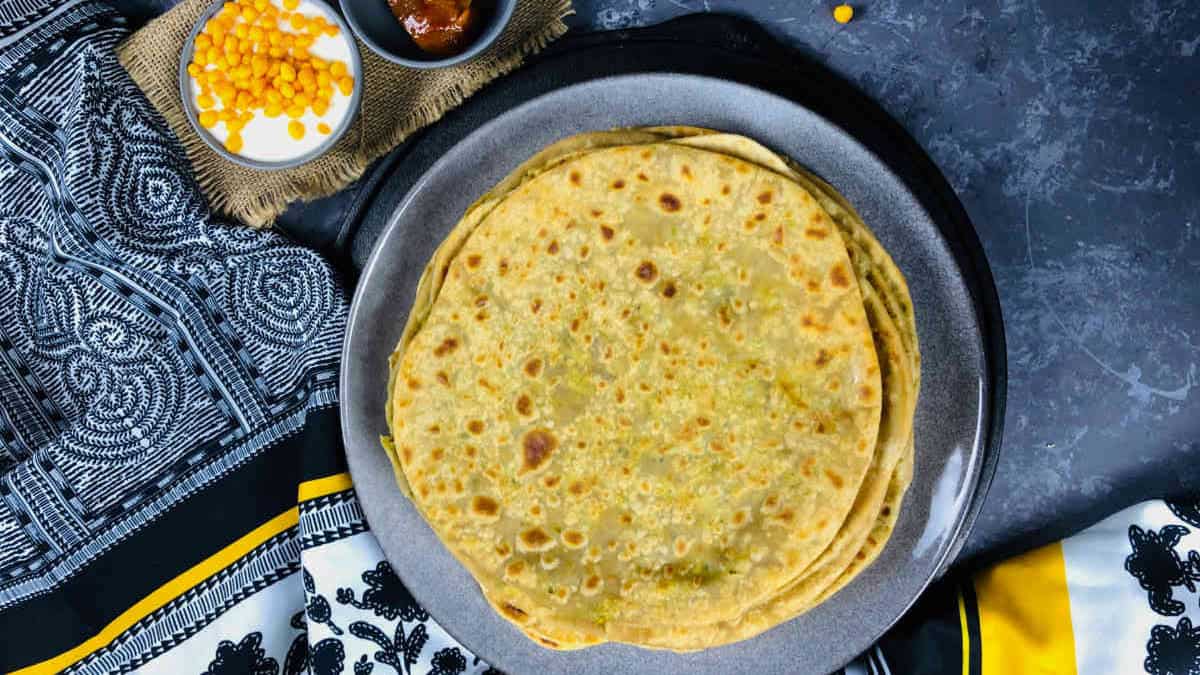 A stack of peas paratha on a grey plate.