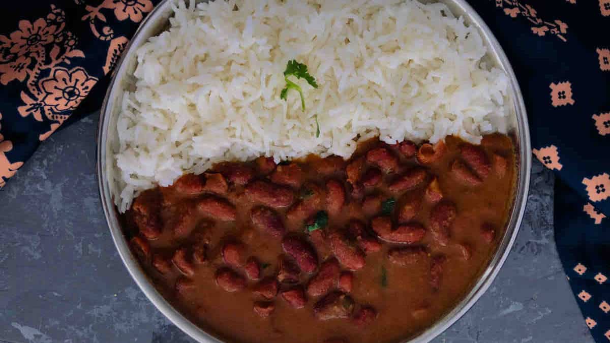 Rajma masala served with rice on a steel plate.