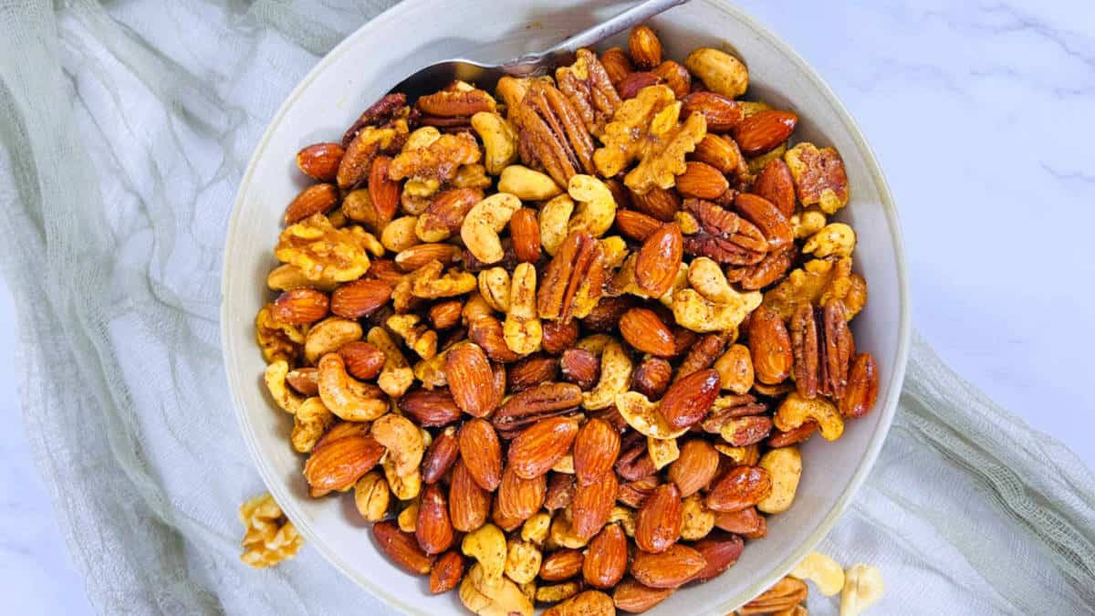 Masala roasted nuts in a white bowl.