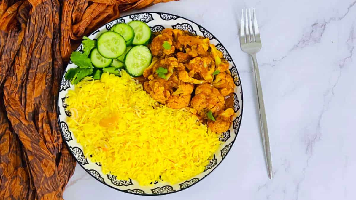 Saffron rice served with cauliflower curry and salad.