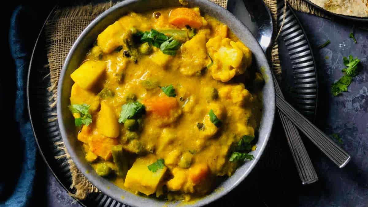 Vegetable korma served in a grey bowl.