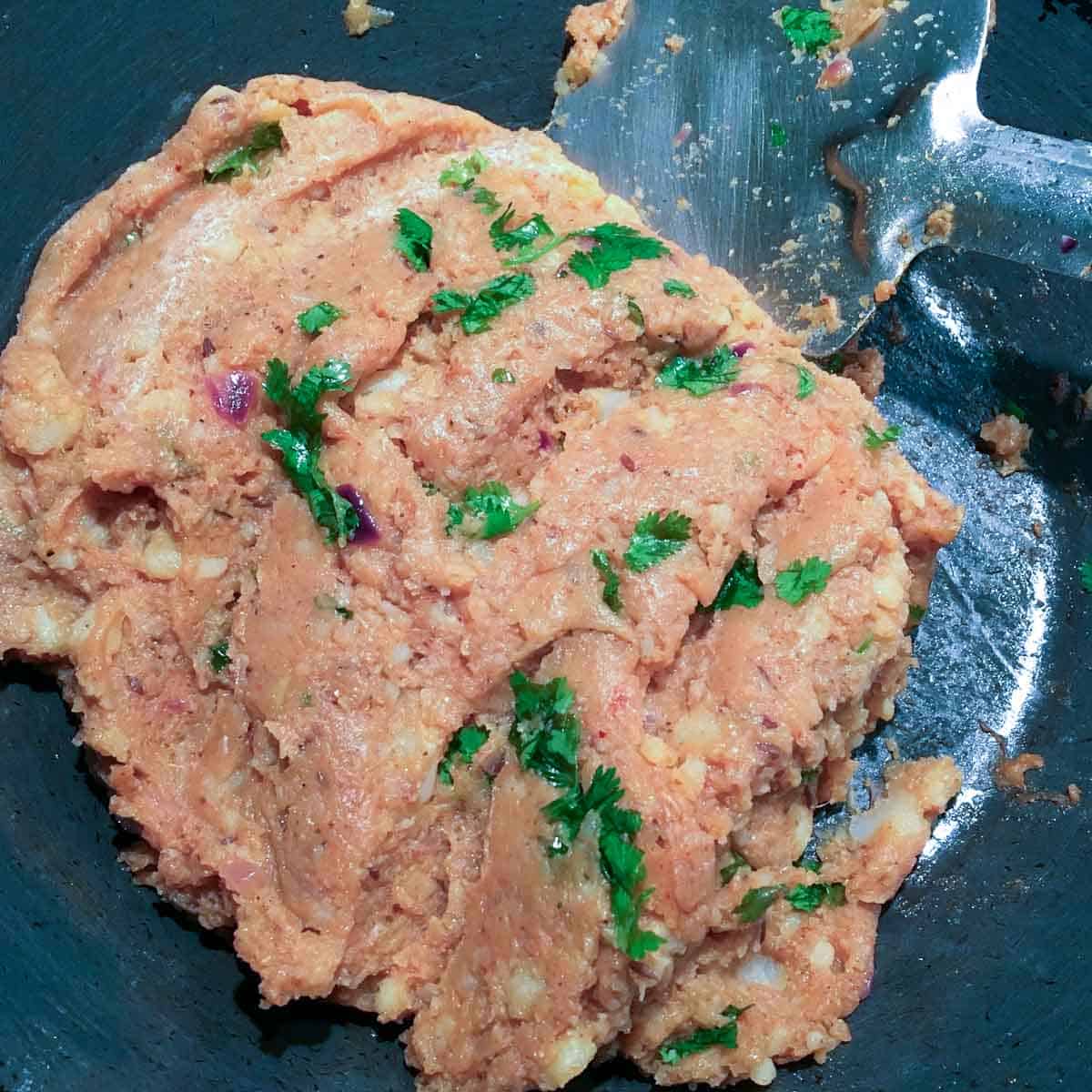 Step showing the addition of potatoe and spices to make the paratha filling.