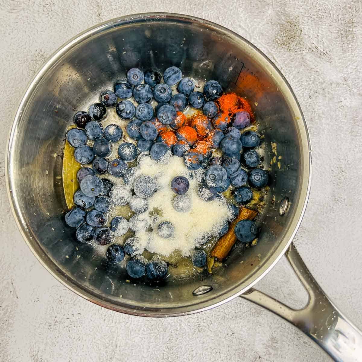 Step showing the addition of blueberries and remaining ingredients.