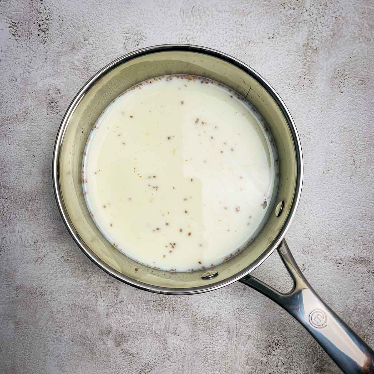 Cardamom infused milk in a saucepan.