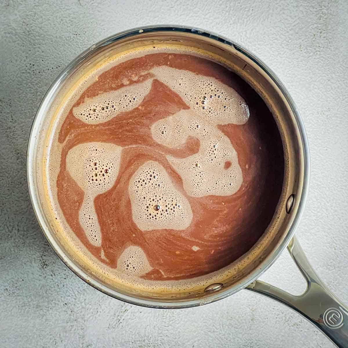Cardamom hot chocolate in a saucepan.