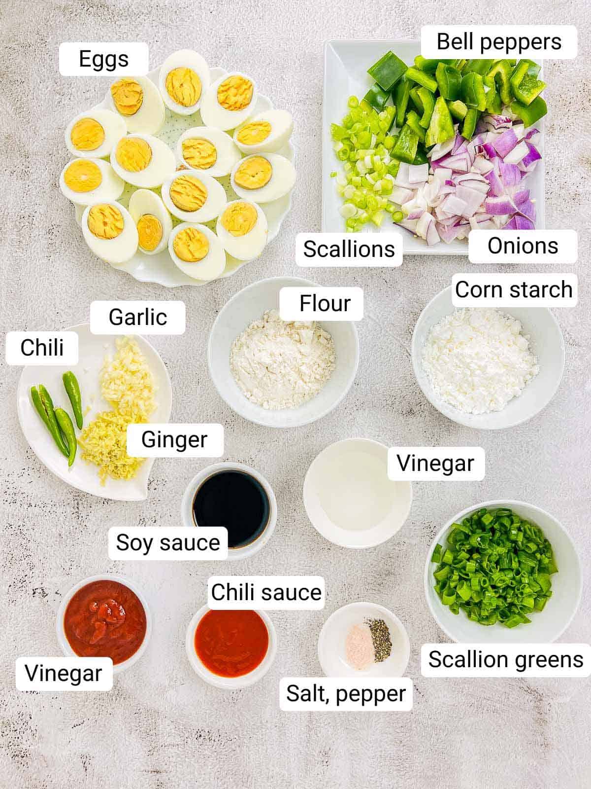 Ingredients to make chilli eggs placed on a white surface.