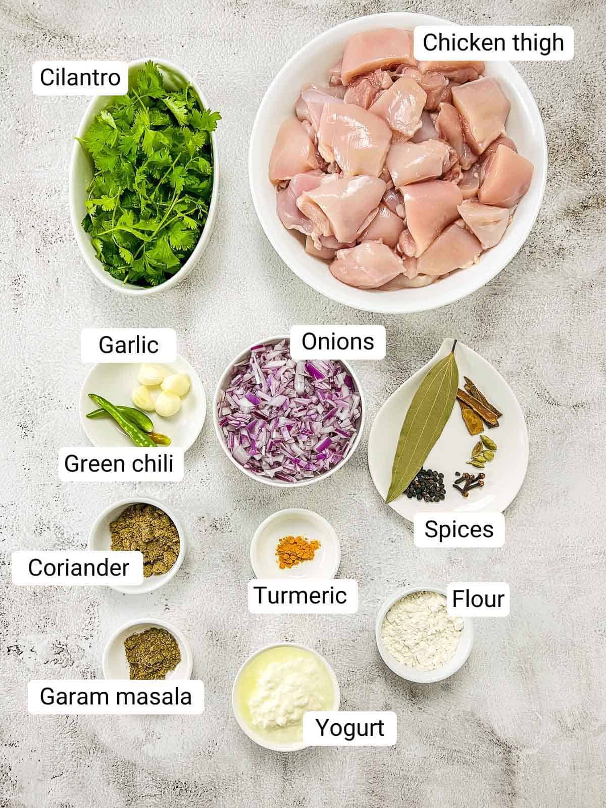 Ingredients to make cilantro chicken placed on a white surface.