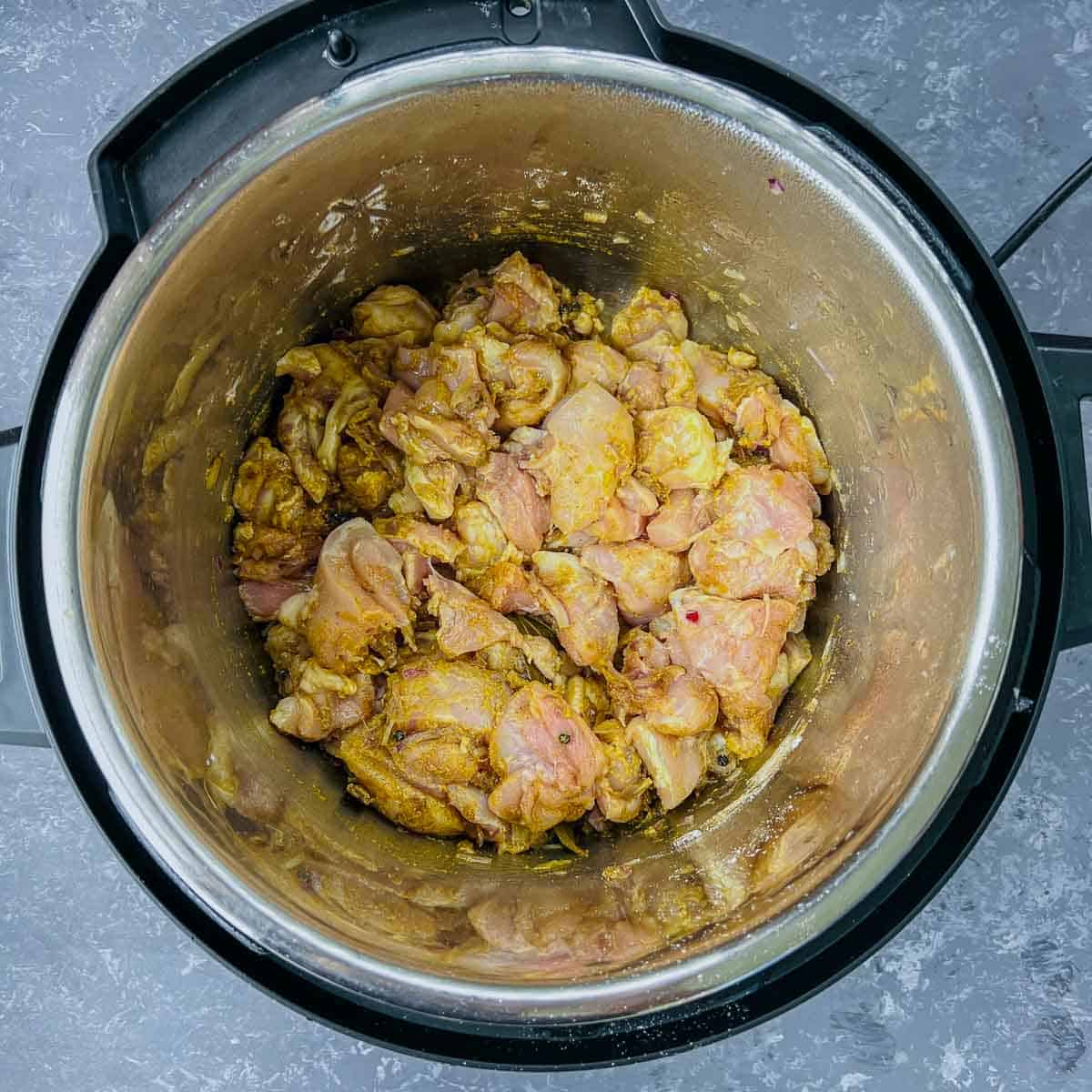 Sauted chicken and ground spices in the Instant Pot.