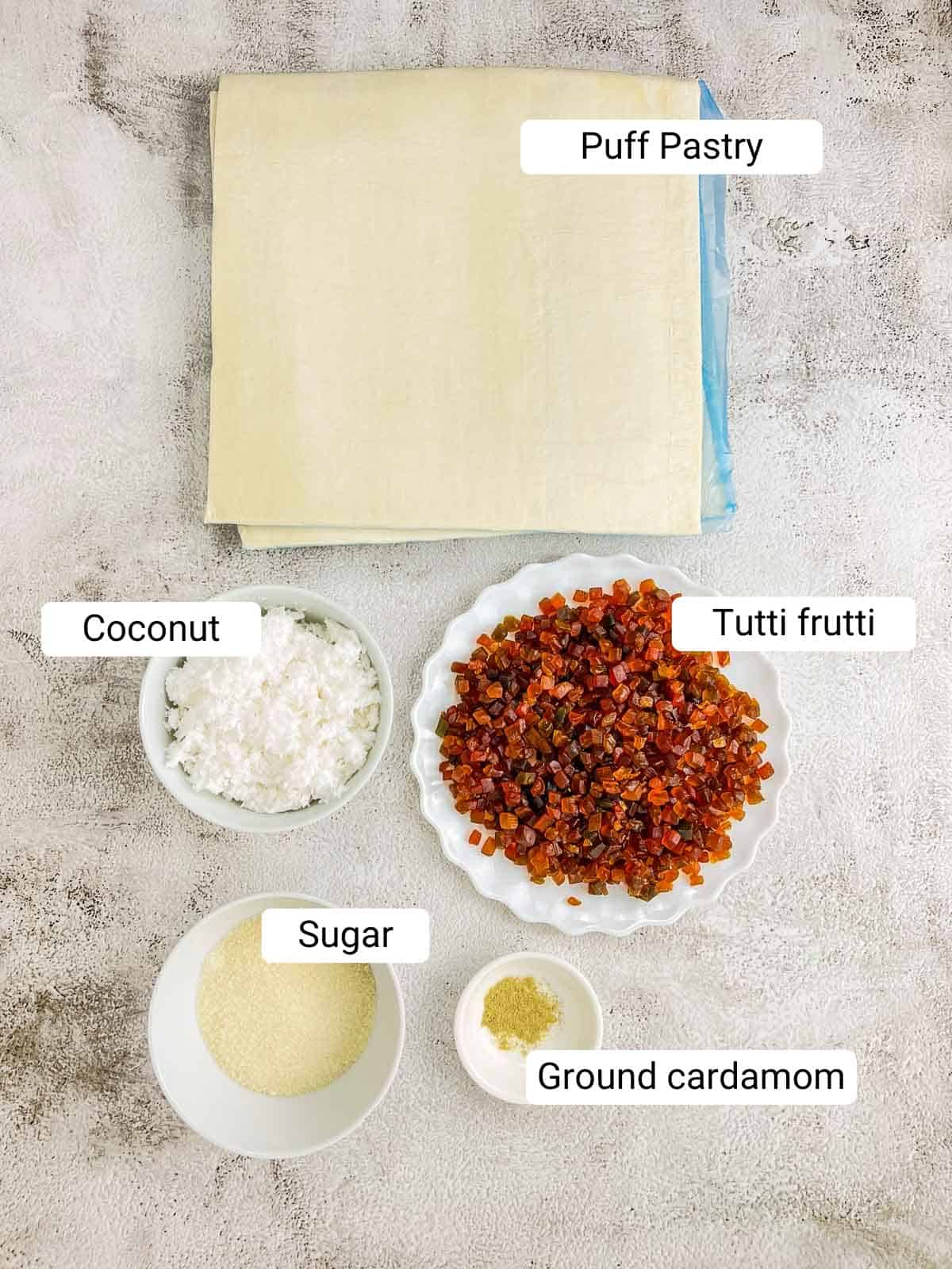 Ingredients needed to make dilpasand placed on a white surface.