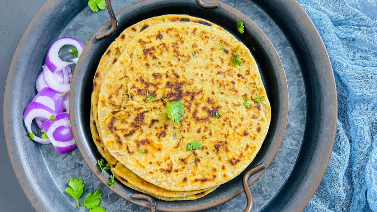 A stack of gobi paratha on a black plate.