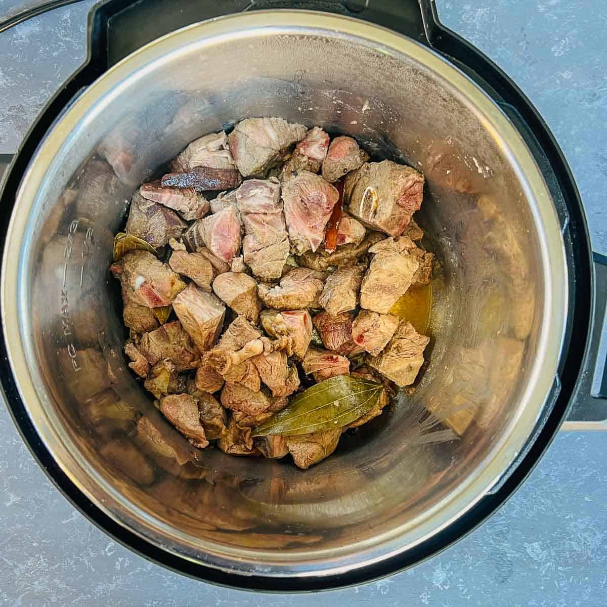 Browned lamb pieces in the Instant Pot.