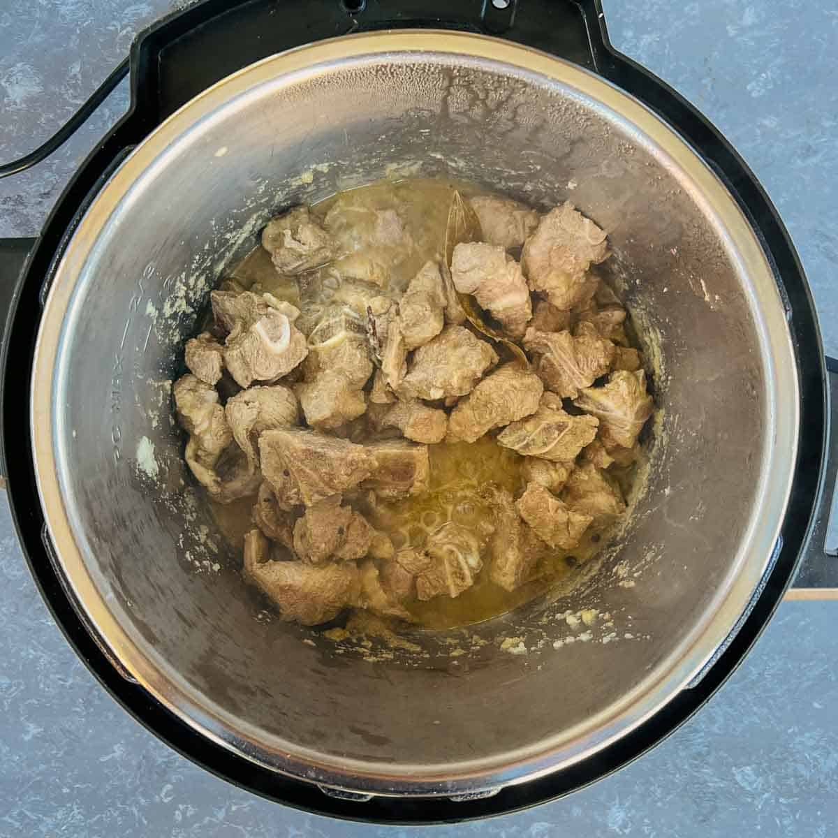 Cooked onion paste along with lamb in the Instant Pot.