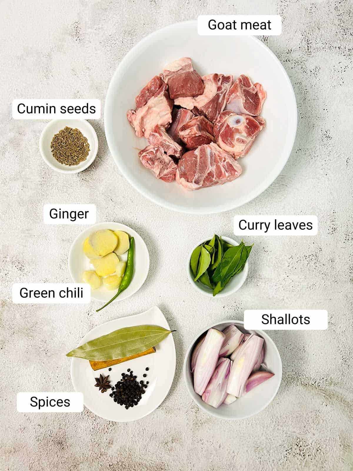Ingredients to make goat soup placed on a white surface. 