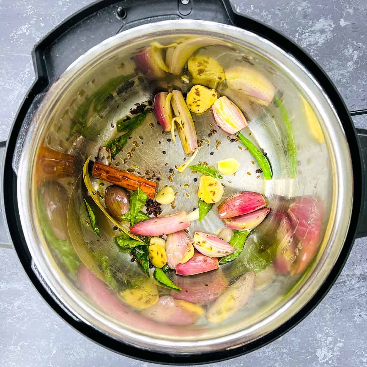 Step showing the sauted spices and aromatics in Instant Pot.
